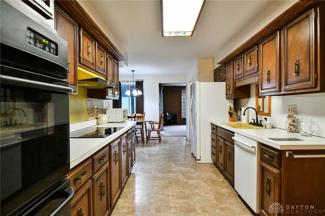 kitchen featuring decorative light fixtures, an inviting chandelier, black appliances, and sink