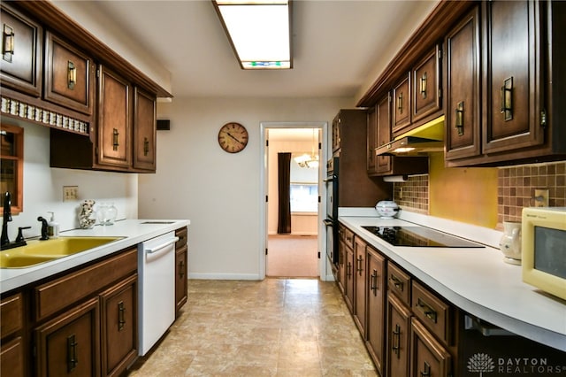 kitchen featuring sink, tasteful backsplash, dark brown cabinetry, and black appliances