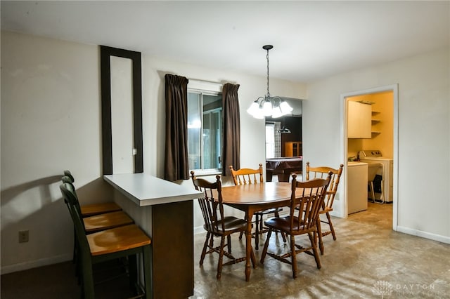 dining space featuring a chandelier and washer and dryer