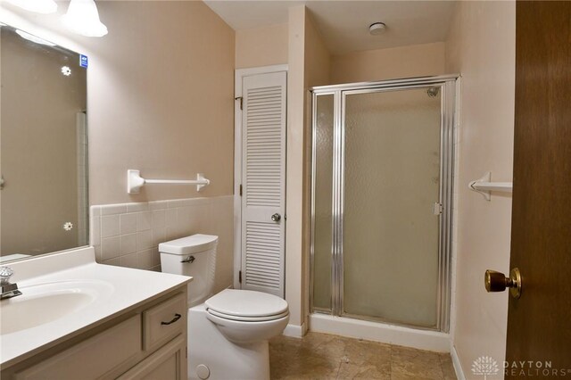 bathroom with tile patterned floors, vanity, toilet, and an enclosed shower