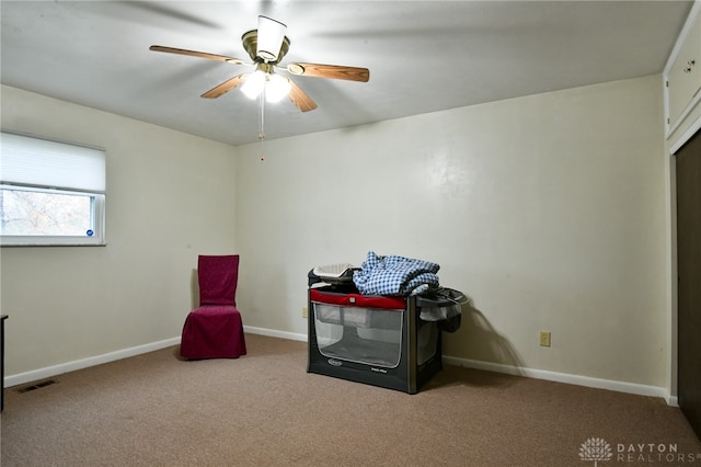 interior space featuring light colored carpet and ceiling fan