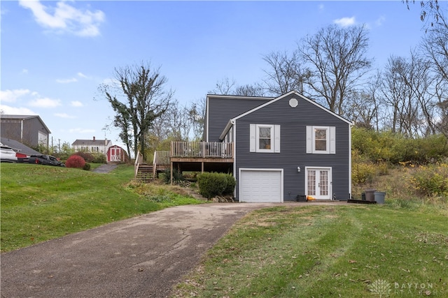 view of side of home with french doors, a yard, a garage, and a wooden deck