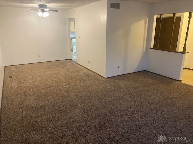 carpeted spare room with ceiling fan