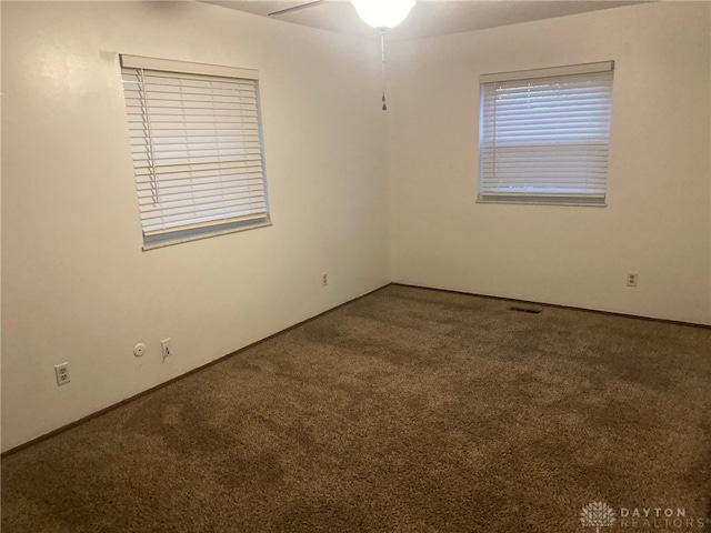 carpeted spare room featuring ceiling fan