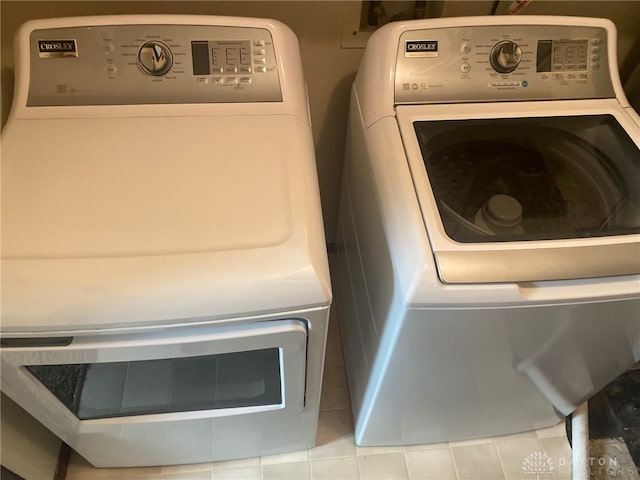 laundry area featuring washing machine and clothes dryer and light tile patterned floors