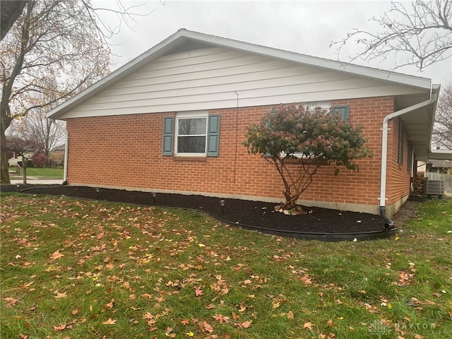 view of side of property featuring a lawn and central AC unit