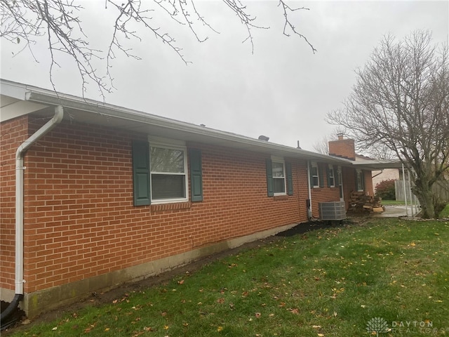 view of side of home featuring a yard and cooling unit