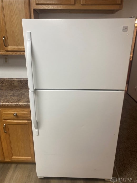 room details with hardwood / wood-style floors and white fridge