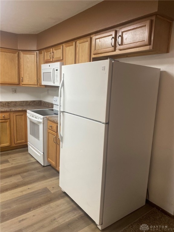 kitchen with light wood-type flooring and white appliances