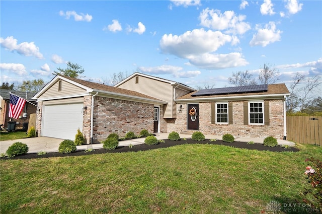 view of front of house with solar panels, a garage, and a front yard