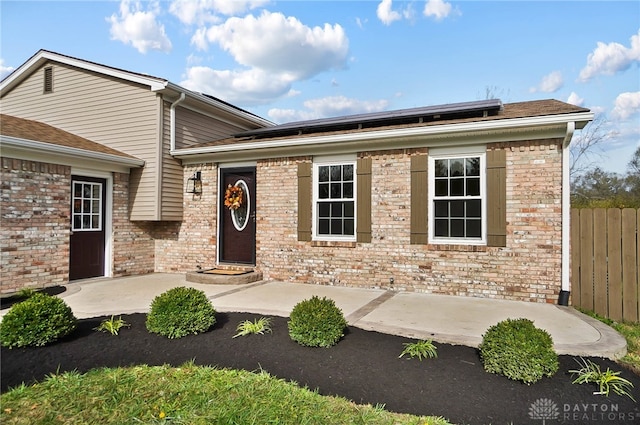 view of front facade with solar panels and a patio