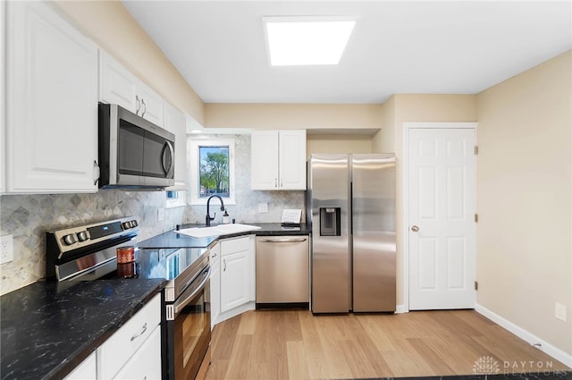 kitchen with white cabinets, light wood-type flooring, stainless steel appliances, and sink