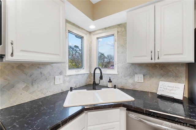 kitchen with decorative backsplash, sink, white cabinets, and stainless steel dishwasher