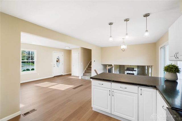 kitchen featuring pendant lighting, light wood-type flooring, and white cabinetry