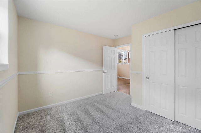 unfurnished bedroom featuring light carpet and a closet