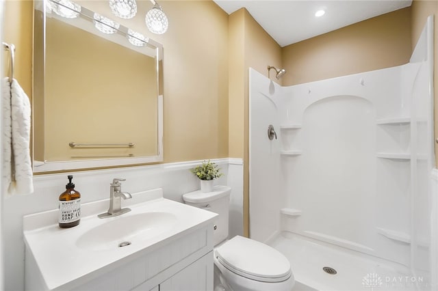 bathroom with a shower, vanity, and toilet