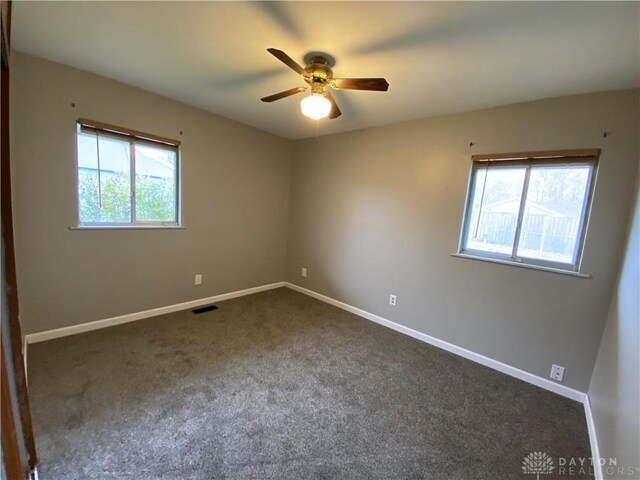 carpeted spare room with ceiling fan