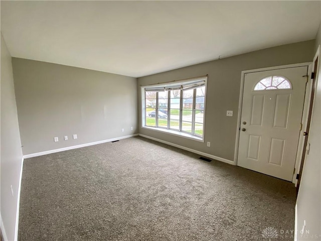 foyer entrance featuring carpet flooring