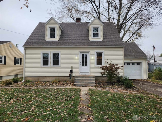 cape cod house featuring a garage and a front lawn