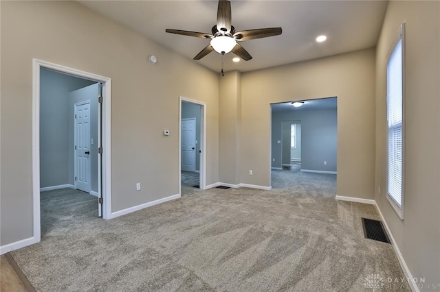 unfurnished bedroom with ceiling fan and light colored carpet