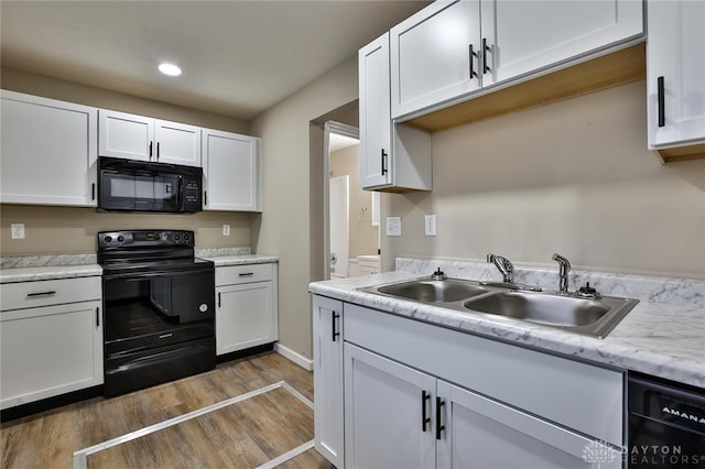 kitchen with black appliances and white cabinetry