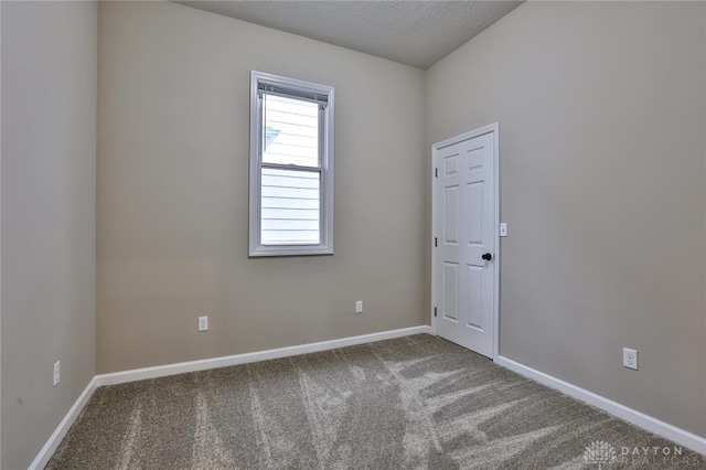 carpeted spare room featuring a textured ceiling