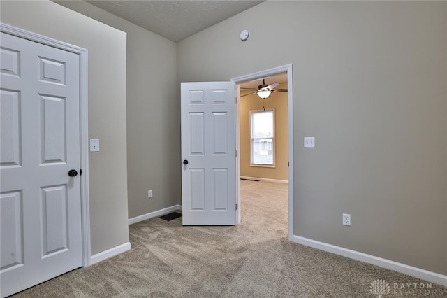 unfurnished room featuring a textured ceiling, light colored carpet, and ceiling fan