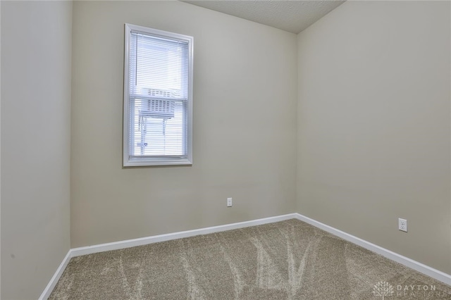 spare room featuring carpet flooring and a textured ceiling