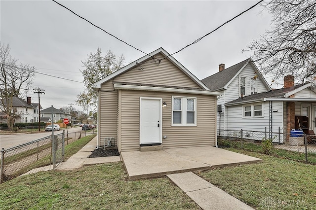 back of property with a yard and a patio