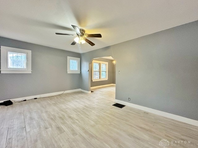 unfurnished room featuring plenty of natural light, ceiling fan, and light hardwood / wood-style flooring