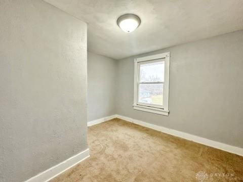 carpeted empty room with baseboards