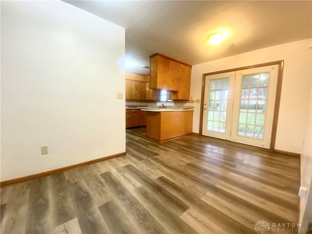 kitchen featuring sink, dark hardwood / wood-style flooring, kitchen peninsula, and a textured ceiling