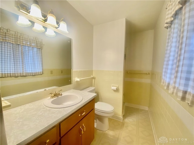 bathroom with vanity, tile walls, and toilet