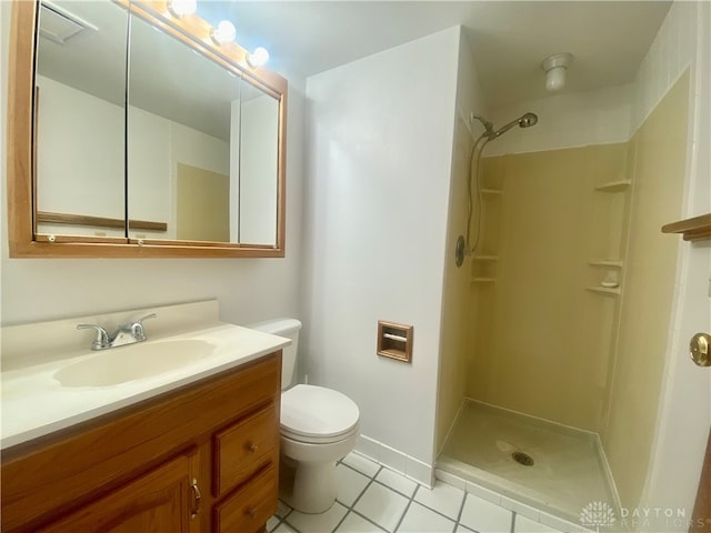 bathroom with tile patterned floors, vanity, toilet, and a shower