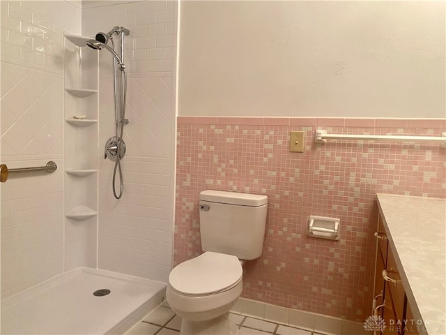 bathroom featuring tile patterned floors, vanity, toilet, and tile walls