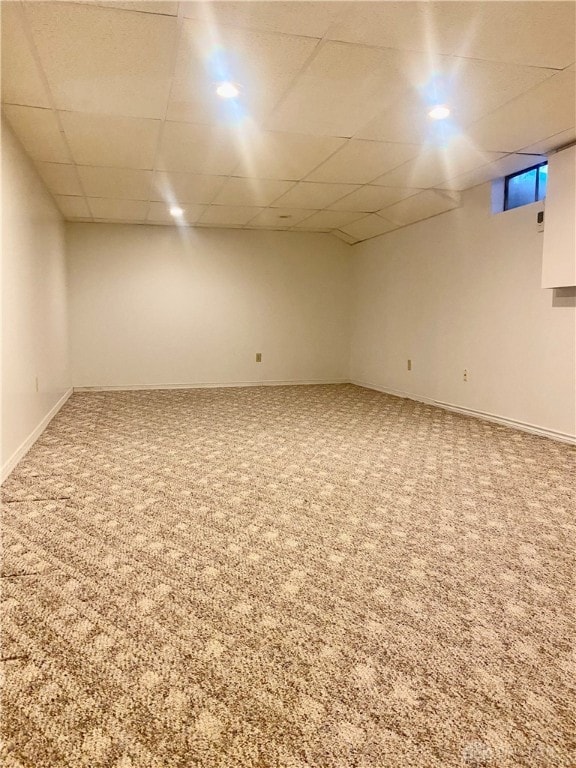 basement with carpet flooring and a paneled ceiling