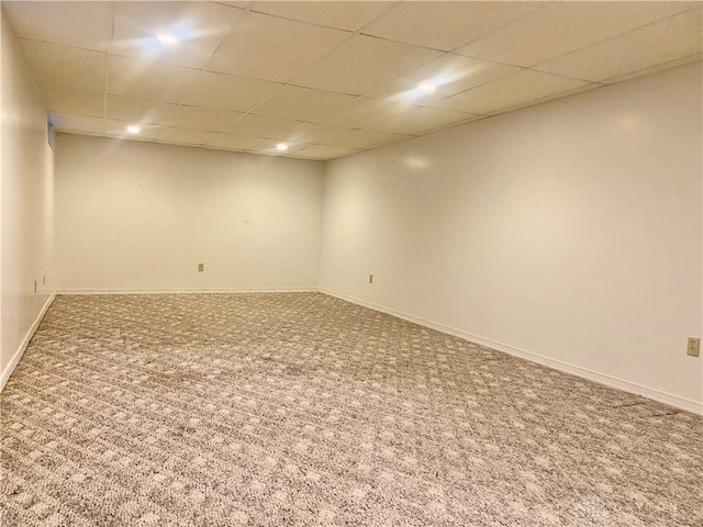 carpeted spare room with a drop ceiling