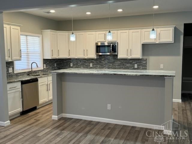 kitchen featuring white cabinets, hanging light fixtures, and appliances with stainless steel finishes