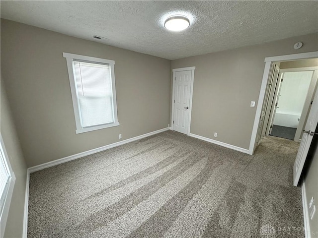 spare room with carpet floors and a textured ceiling