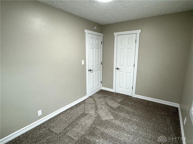 empty room featuring carpet and a textured ceiling