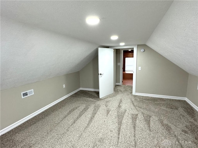 bonus room featuring carpet, a textured ceiling, and vaulted ceiling