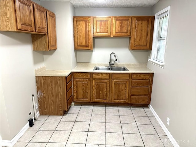 kitchen with sink, light tile patterned floors, and a textured ceiling