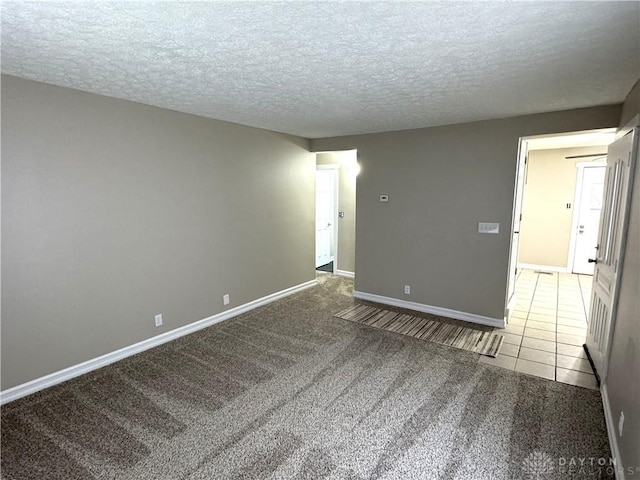 carpeted empty room featuring a textured ceiling