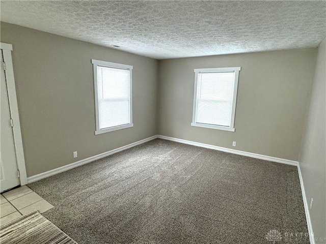 carpeted spare room with a textured ceiling