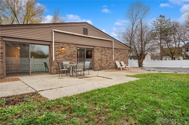 rear view of house with a lawn and a patio area