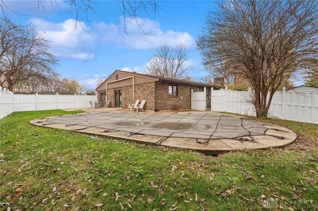 rear view of property featuring a lawn and a patio area