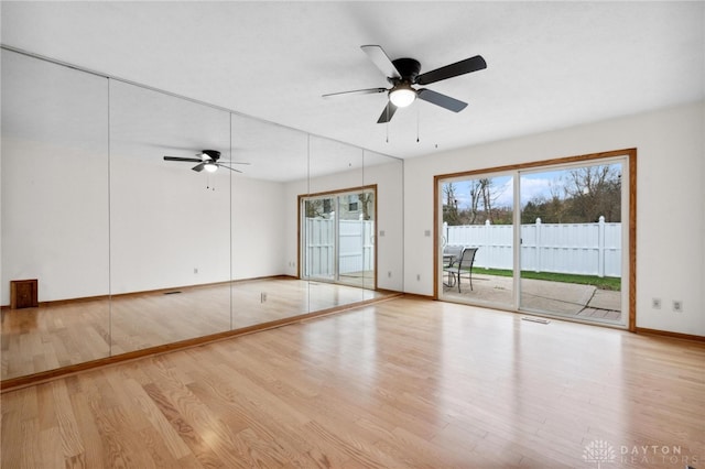 spare room with ceiling fan and light wood-type flooring