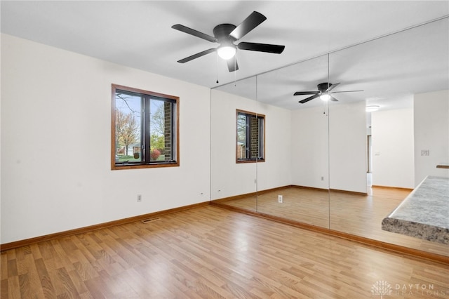 empty room with light hardwood / wood-style floors and ceiling fan