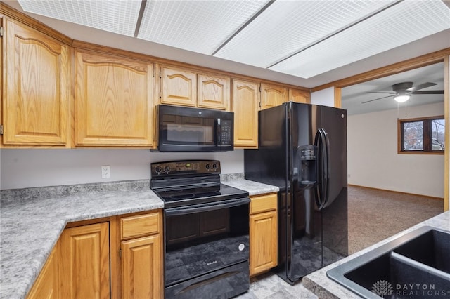 kitchen featuring black appliances, ceiling fan, and light carpet