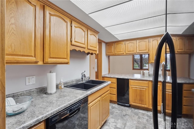 kitchen with light stone counters, sink, and black dishwasher